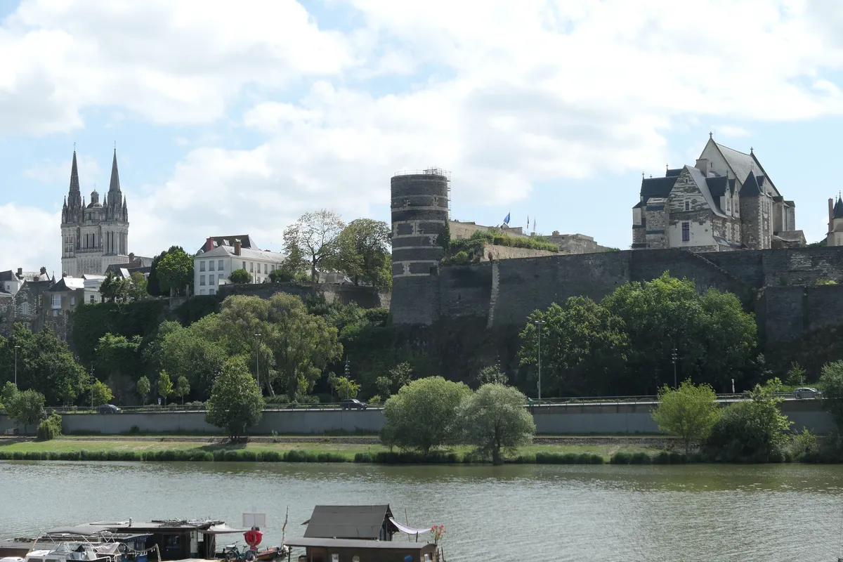 Les remparts du château d'Angers et ses bâtiments au-dessus de la Maine, avec les deux flèches de la cathédrale à gauche, vus de la rive opposée