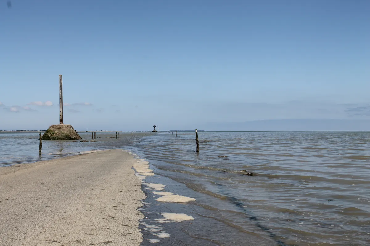 La chaussée du Gois en partie recouverte par la marée, avec une balise refuge