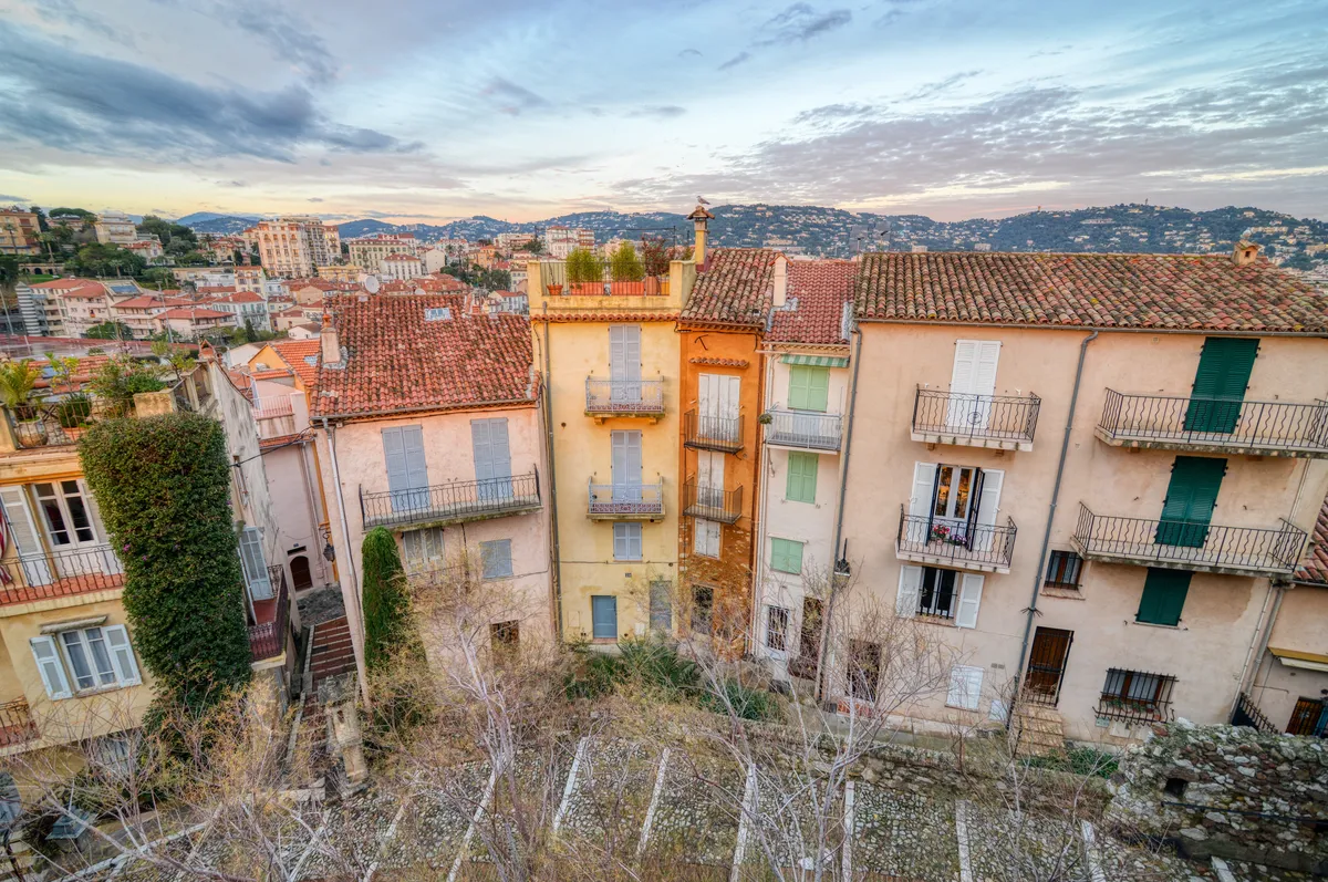 Les façades colorées du Suquet, aux volets verts et aux balcons de fer forgé, au soleil couchant