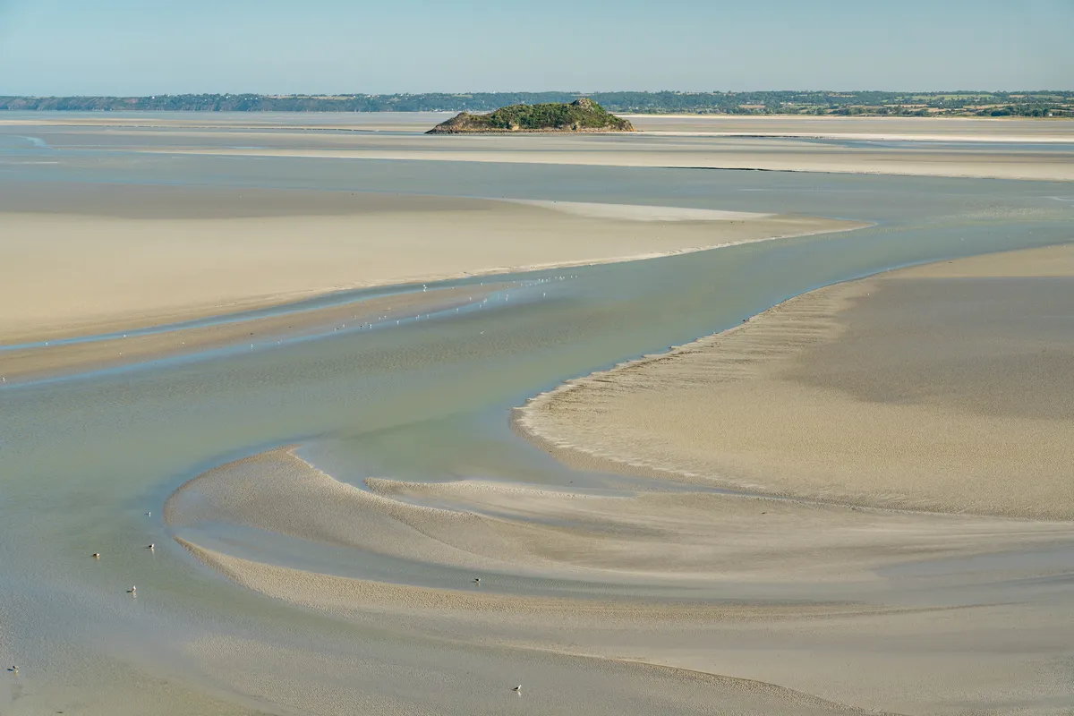 Tombelaine vue des remparts du Mont-Saint-Michel, au-delà des chenaux et des bancs de sable