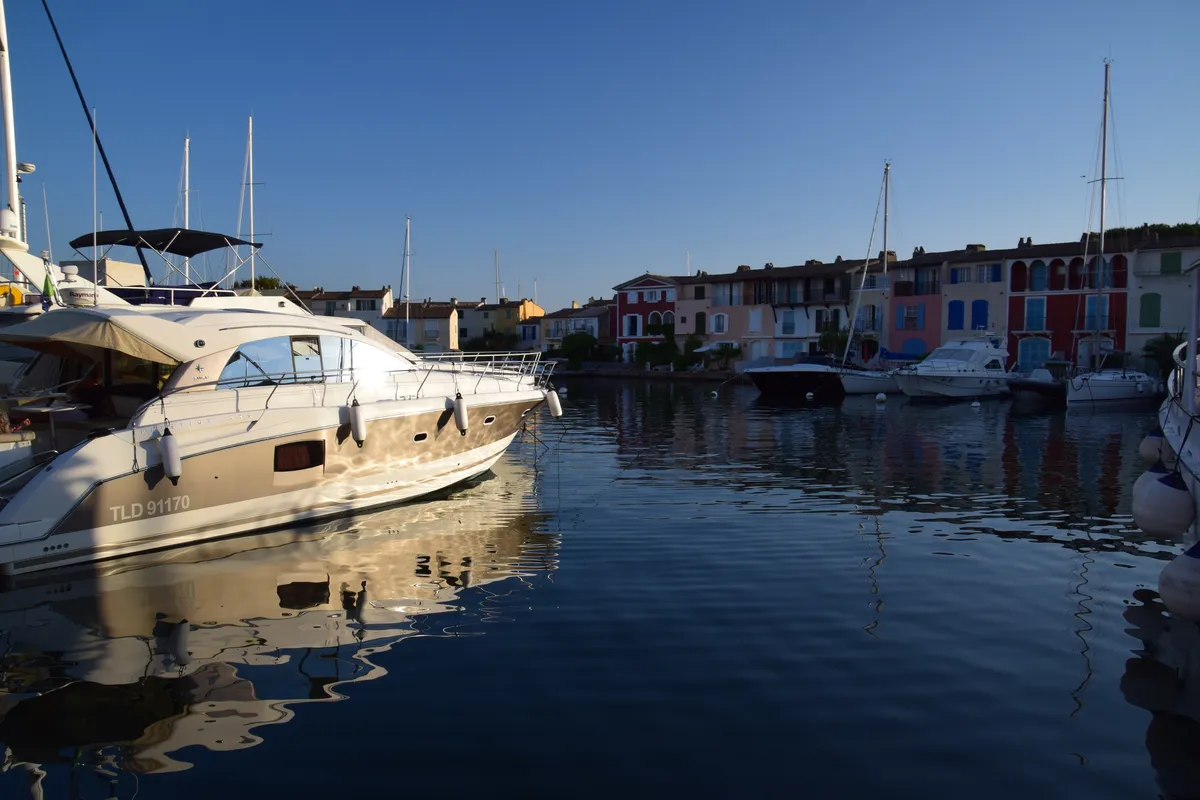 Les canaux de Port Grimaud au soleil couchant, des bateaux amarrés devant les façades colorées