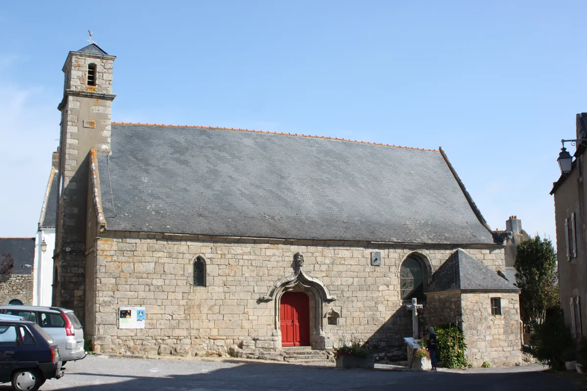 La chapelle Saint-Marc de Kervalet, ses murs de pierre, son clocher et sa porte rouge, sous un ciel bleu