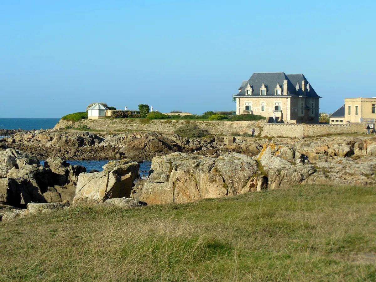 Les rochers de granit et la lande rase de la pointe du Croisic, avec une grande maison de pierre au bord de l'eau