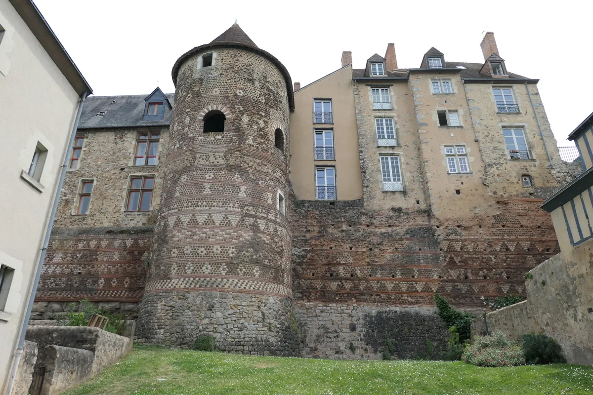La tour du Vivier et la courtine romaine, décorées de frises géométriques de brique et de pierre, sous des maisons