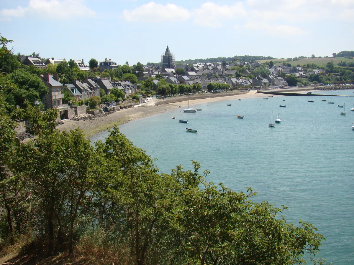 Le village de Saint-Suliac vu des hauteurs, ses maisons de pierre au bord de la Rance et des bateaux au mouillage